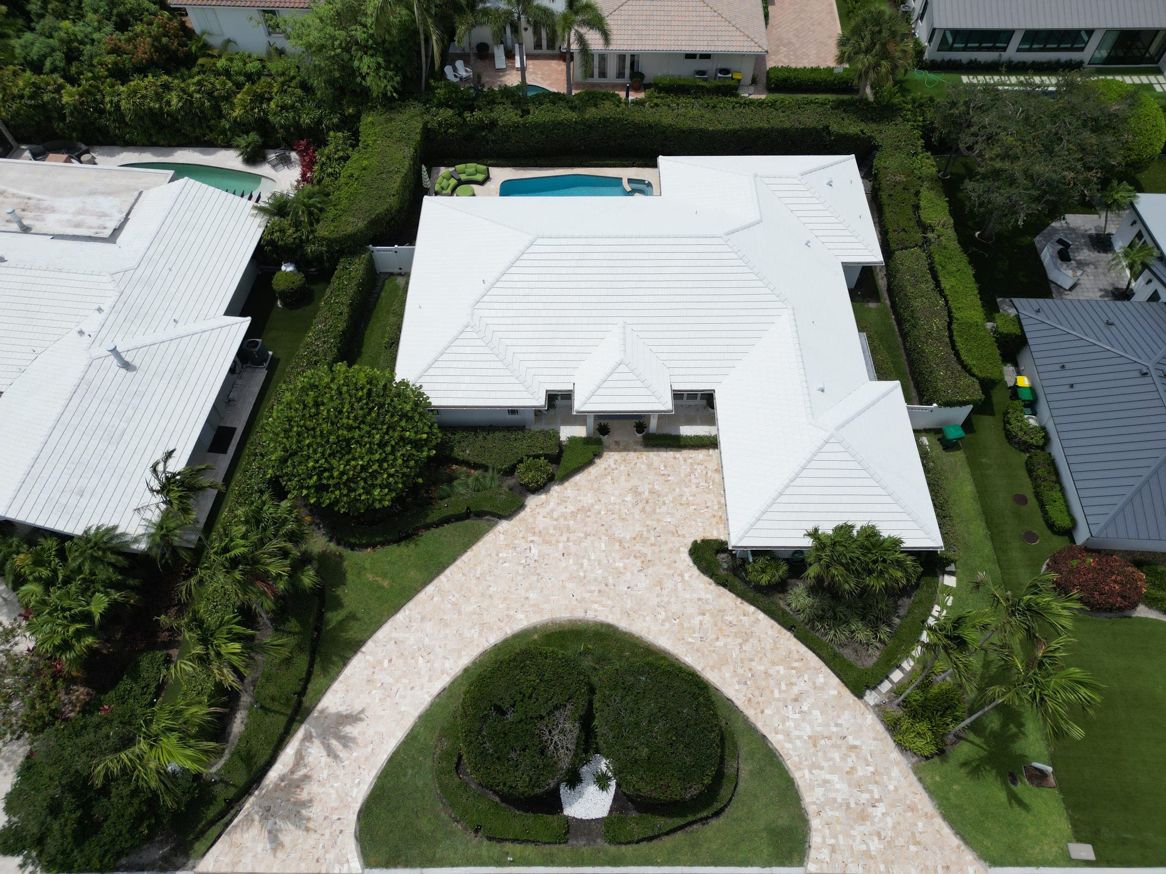 Aerial view of the property showing the travertine driveway, entrance, and landscaping
