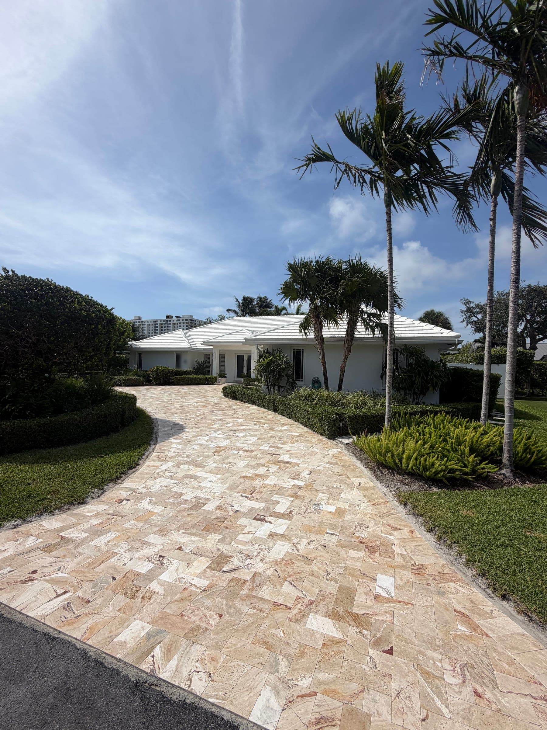 Completed travertine paver driveway viewed alongside the home's entrance