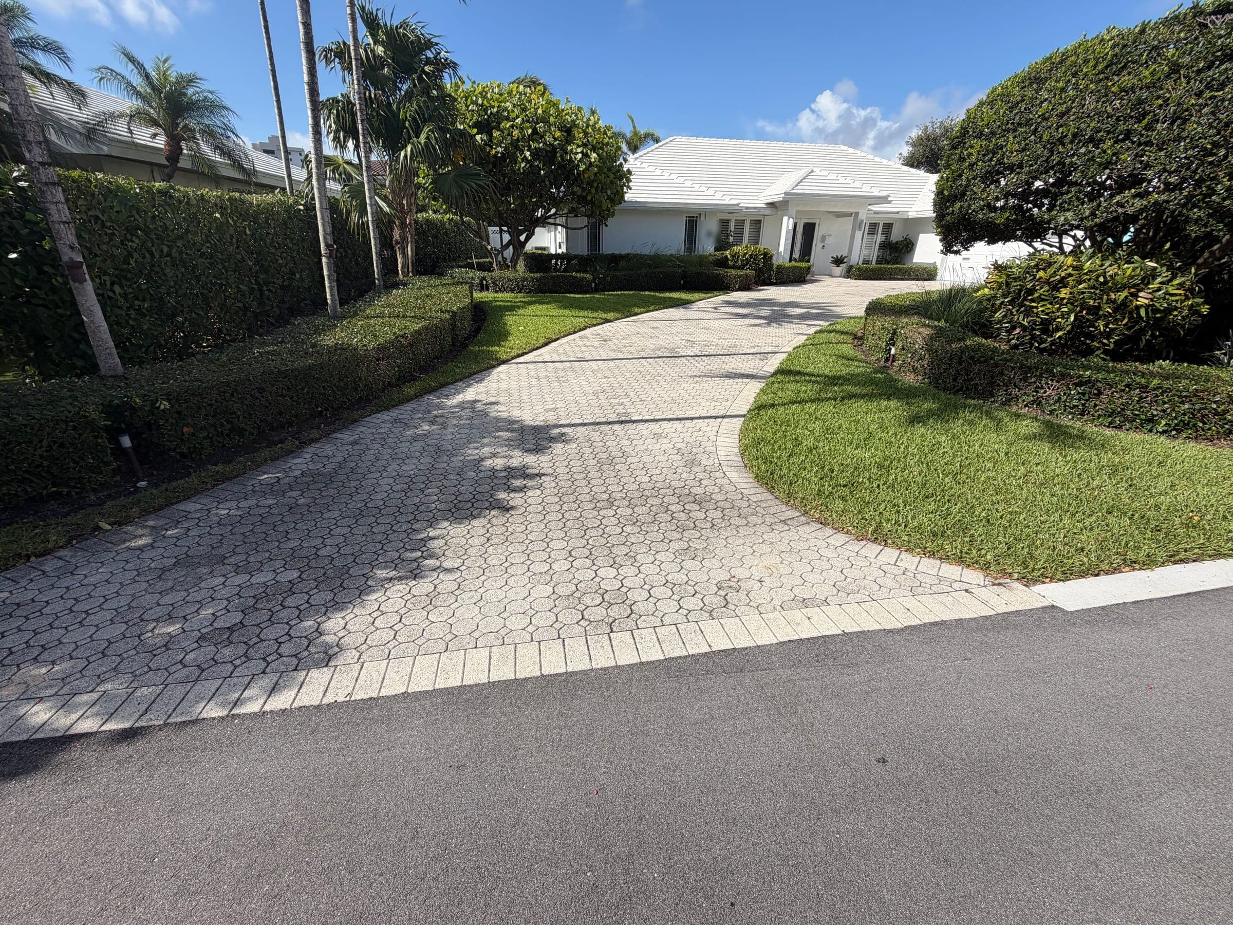 Existing driveway pavers before replacement, approaching the home