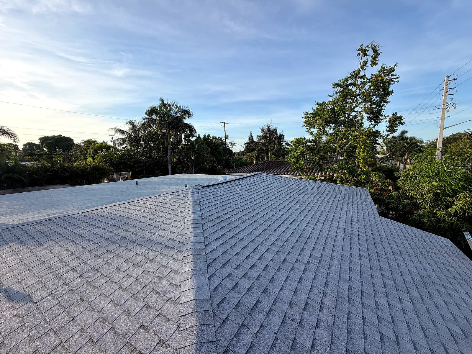Completed architectural shingle roof and modified bitumen flat roof section from a second angle