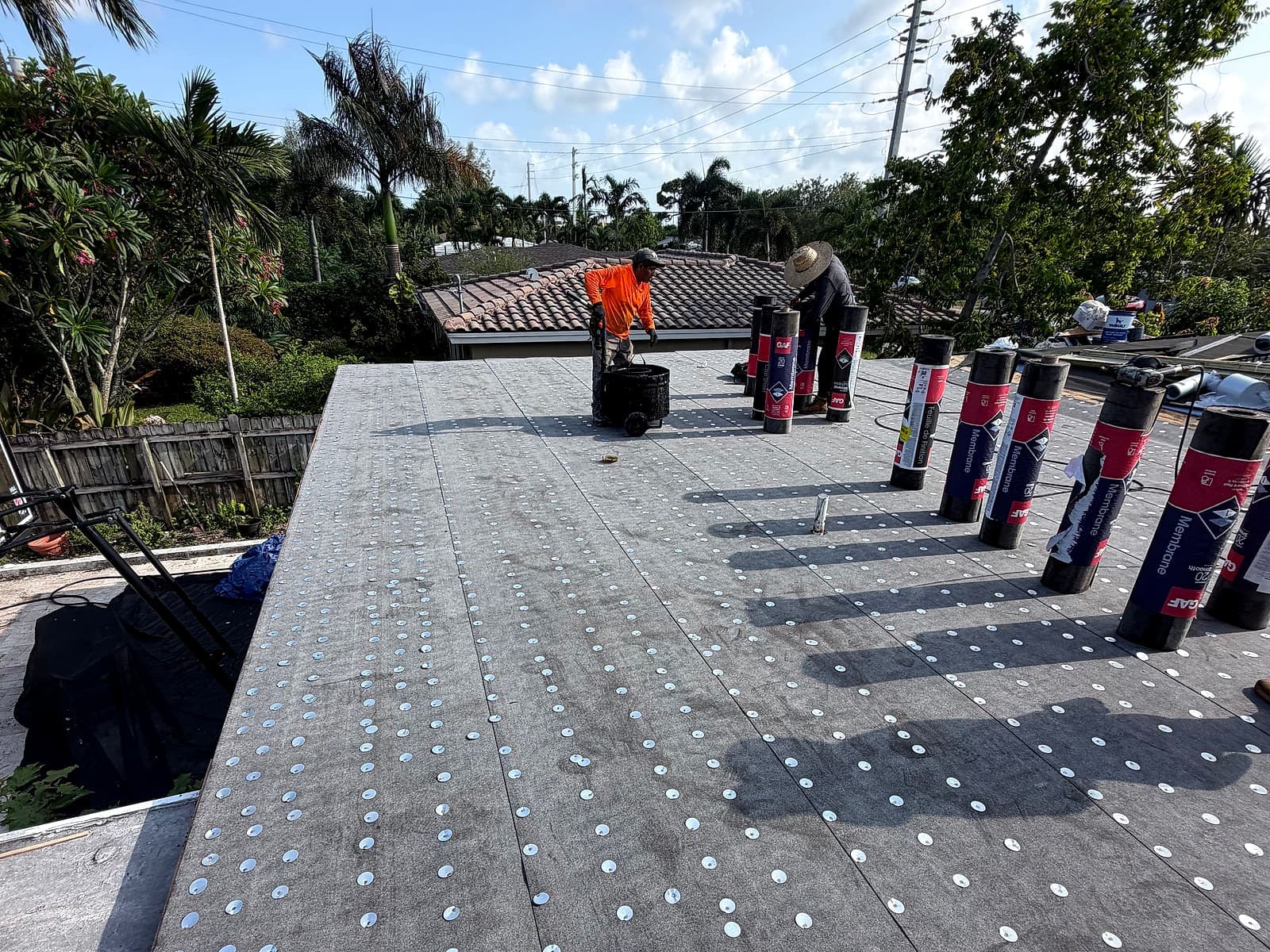 New insulation board and modified bitumen membrane rolls staged during the roof replacement